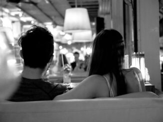 grayscale photo of couple sitting on chair