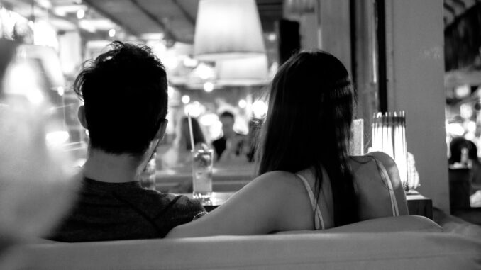 grayscale photo of couple sitting on chair