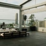 Spacious rooftop patio with modern furniture overlooking a city skyline.