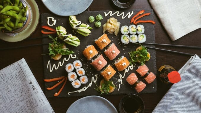 Photo by Jakub Dziubak sushi on black ceramic plate