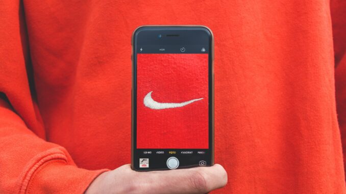 Photo by Kristian Egelund person holding iPhone taking picture on Nike label